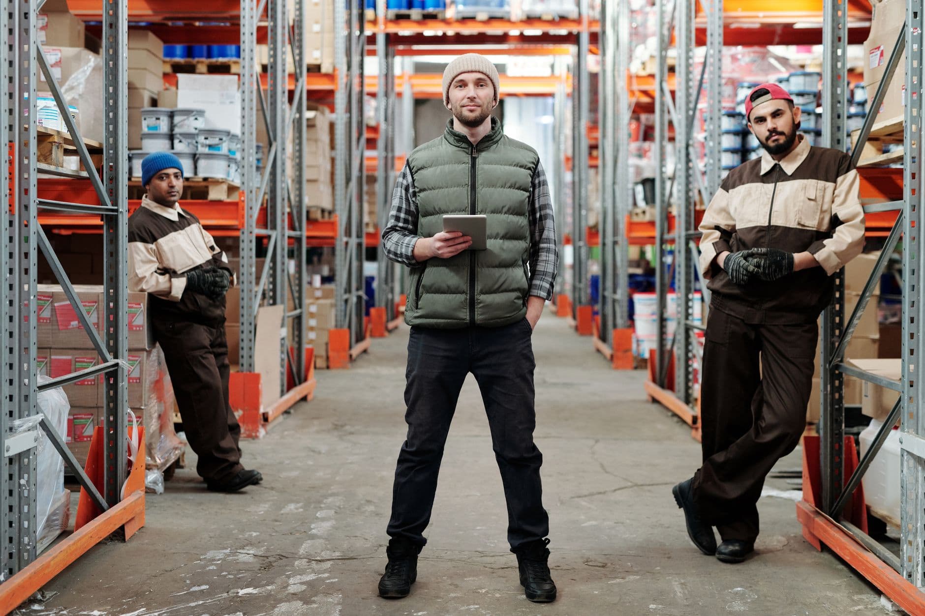 Operations staff walking through a warehouse fulfilment area, checking inventory on a tablet