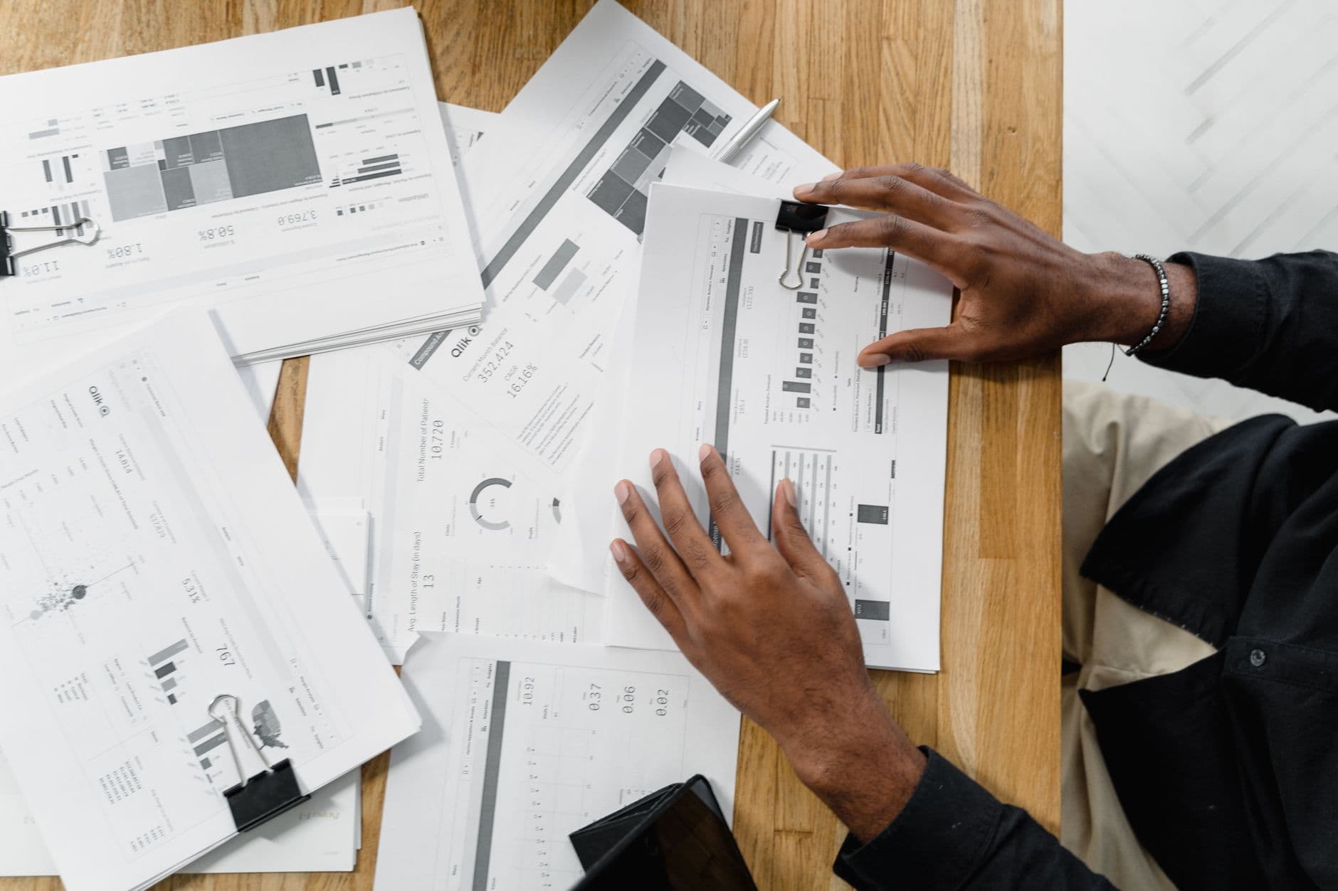 Top view of a professional reviewing financial documents at a desk