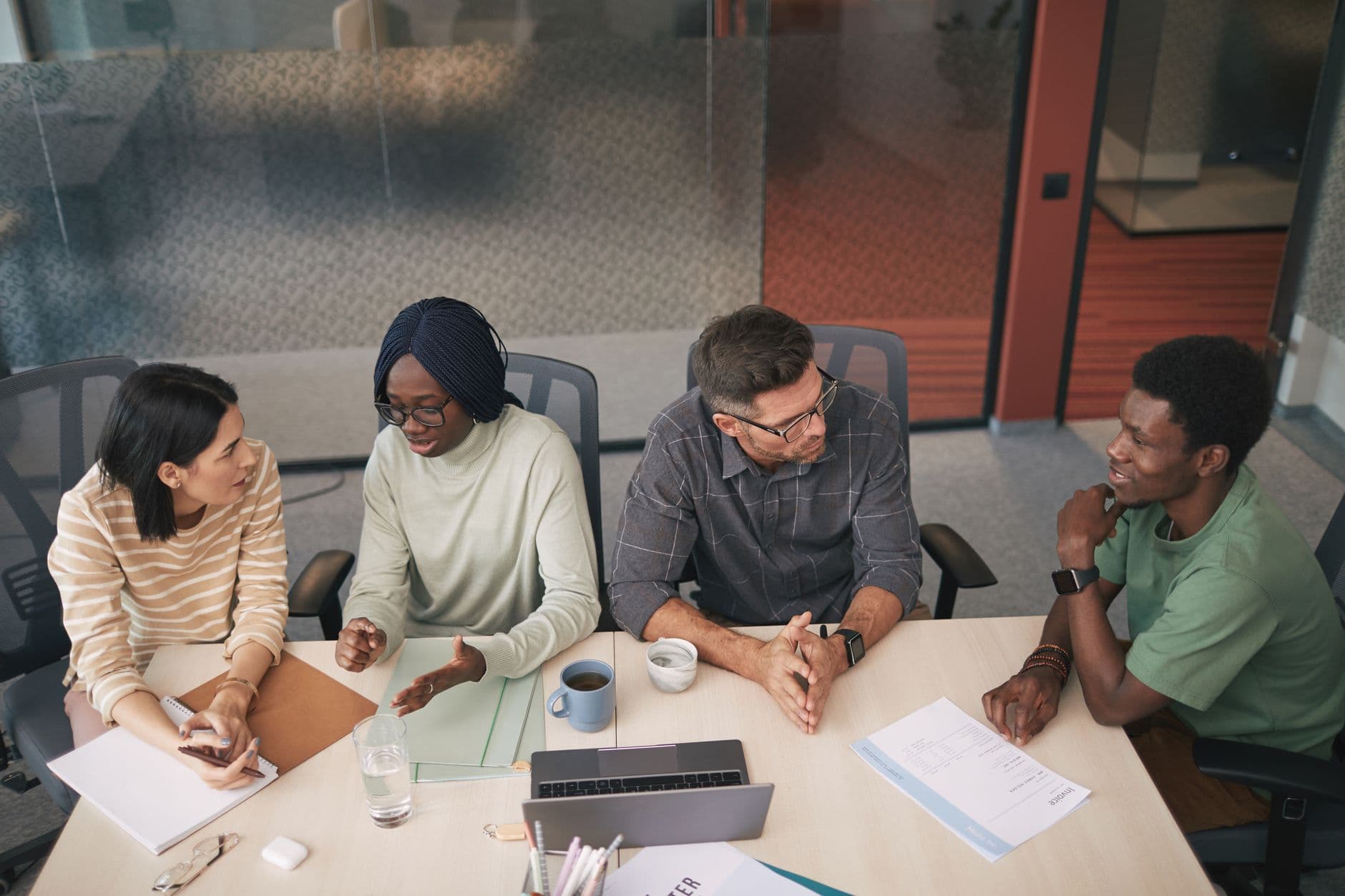 A diverse team collaborating around a table in a bright open office