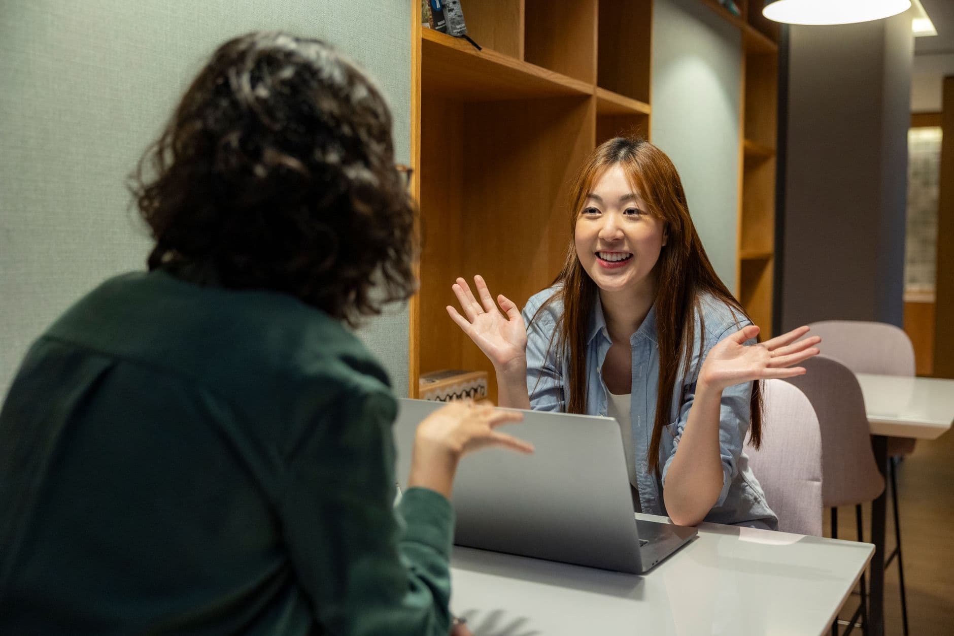 An HR leader running a one-on-one meeting with a team member across a small table